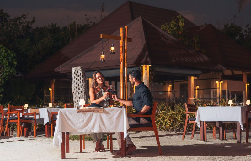VARU by Atmosphere, North Malé Atoll: a couple at dinner outside a restaurant at dusk