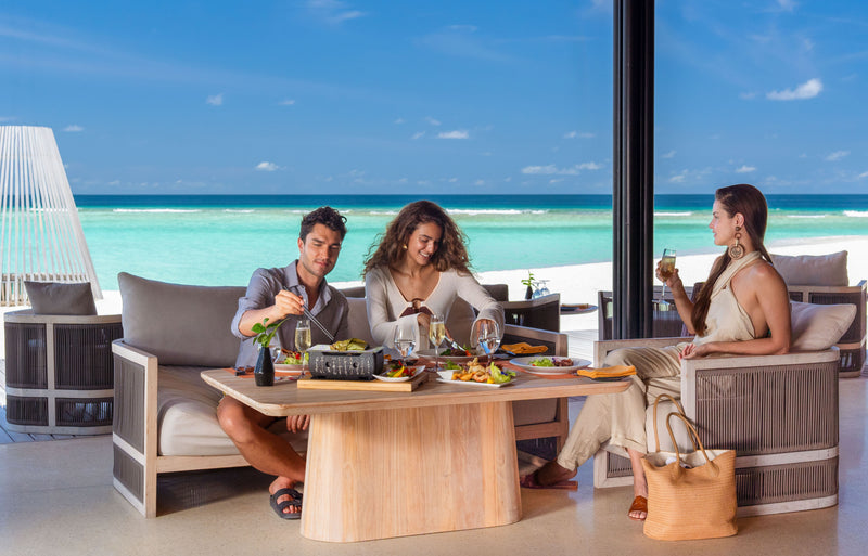 RAAYA by Atmosphere, Raa Atoll: friends sharing lunch on a seaside terrace