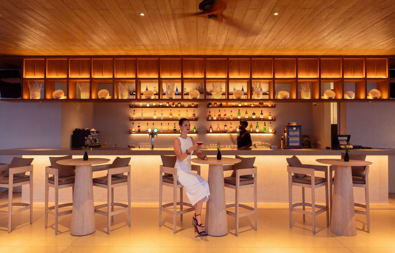 RAAYA by Atmosphere, Raa Atoll: a guest at a lit bar counter