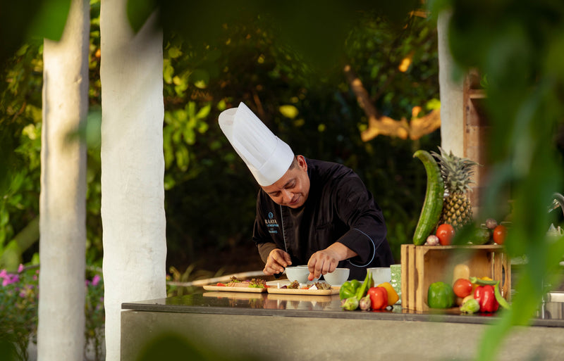 RAAYA by Atmosphere, Raa Atoll: a chef plating a dish at an outdoor station