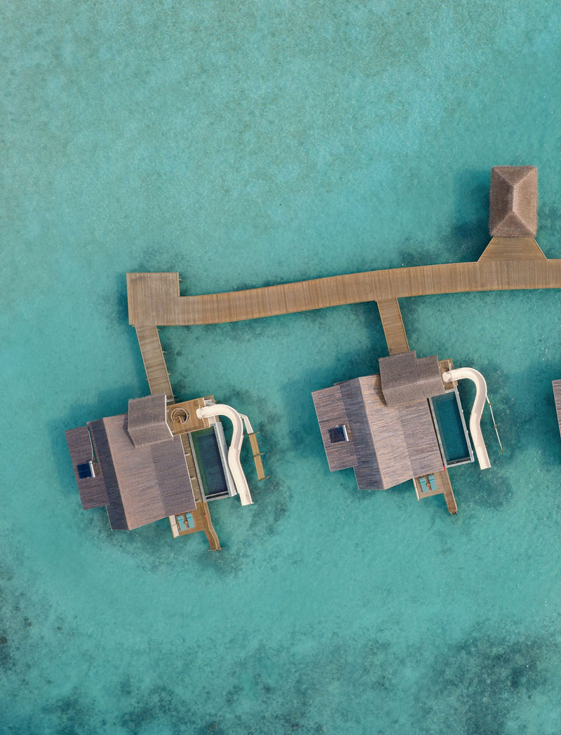 Overwater villas with water slides at RAH GILI Maldives from the air.