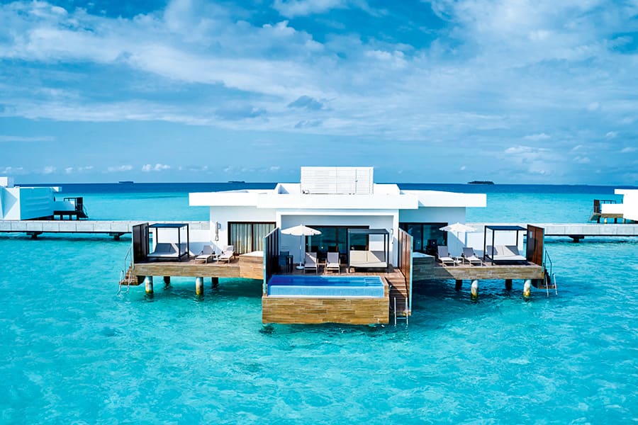 An overwater suite at Hotel Riu Palace Maldivas seen from outside, with its deck and pool.