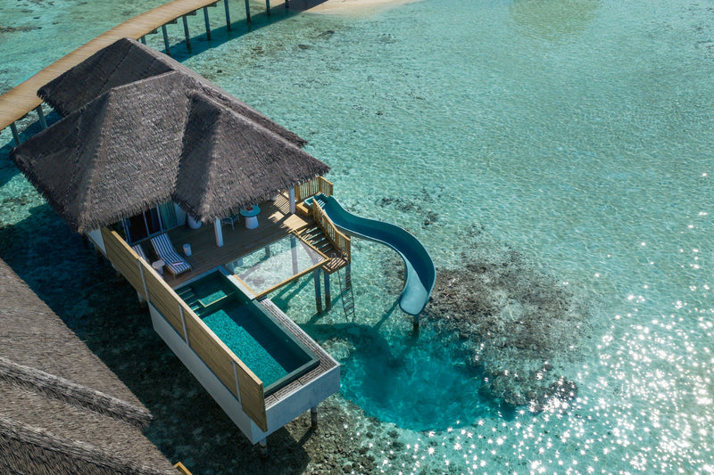 An Ocean Signature Villa with Pool and Slide at Sun Siyam Vilu Reef from above, the slide running from the deck into the lagoon