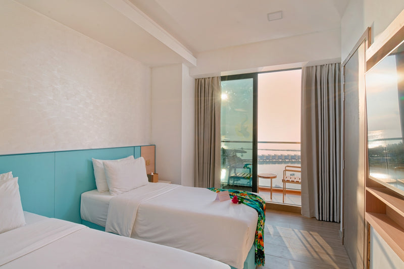h78 Guraidhoo, South Malé Atoll: a twin-bedded room with a balcony door looking out to sea