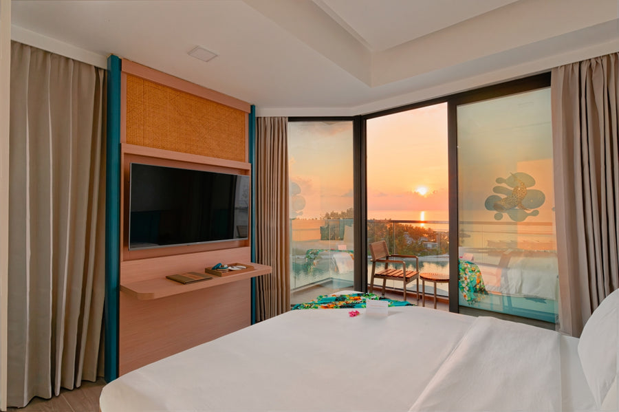 h78 Guraidhoo, South Malé Atoll: a Sunrise Ocean Prime room, the bed facing corner windows and the balcony