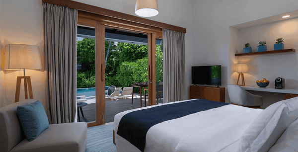 The bedroom of a Sunset Beach Villa with Pool at Ifuru Island Maldives.