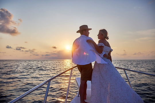 A couple watching the sunset from the bow of a boat on a cruise from Grand Park Kodhipparu