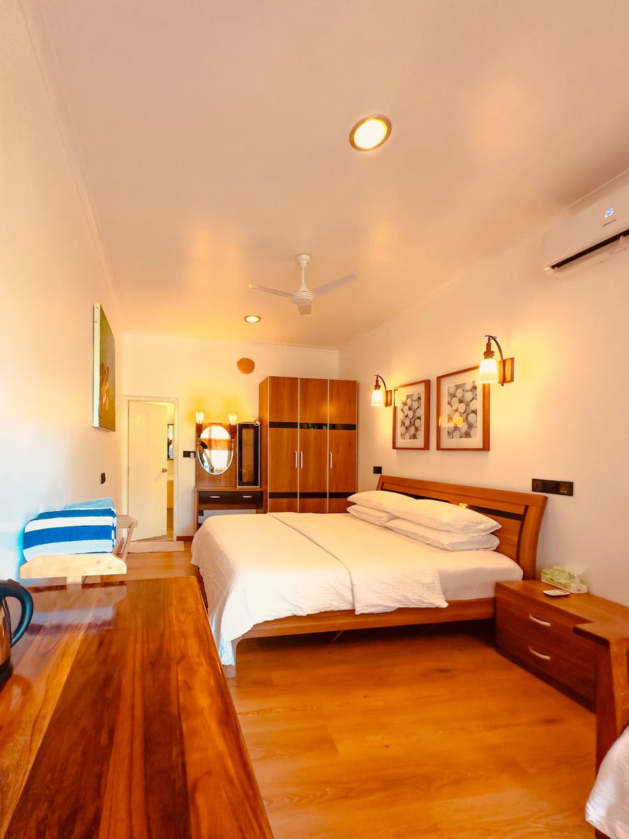 The Sultanate Courtyard, Hinnavaru, Lhaviyani Atoll: Standard room with a double bed, wooden wardrobe and framed prints