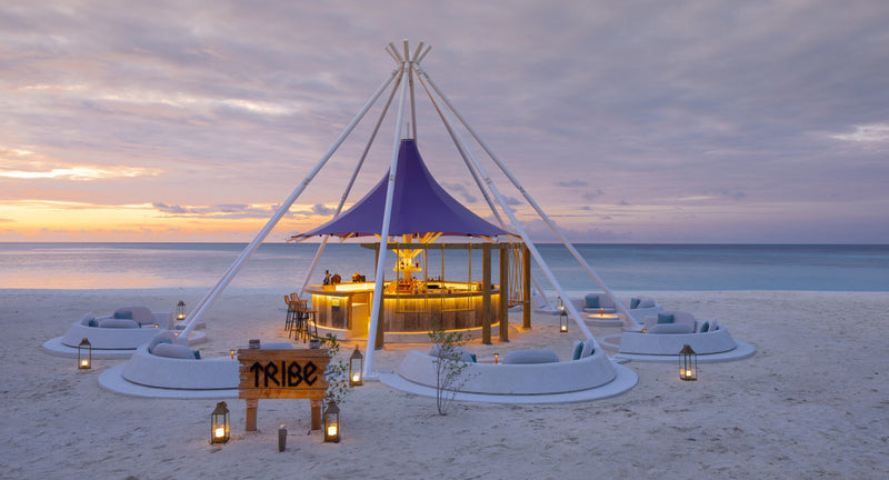 Tribe, the tented sunset beach bar at Avani+ Fares Maldives, at sundown.