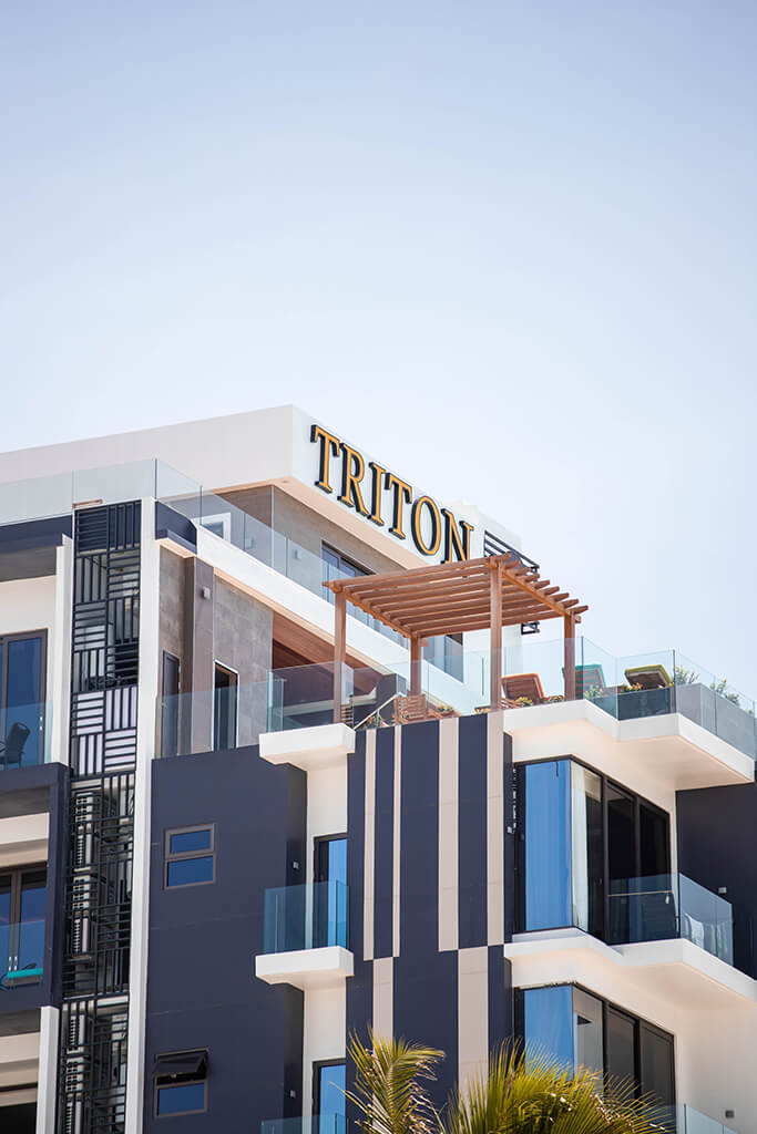 Triton Prestige hotel building with its name on the roofline