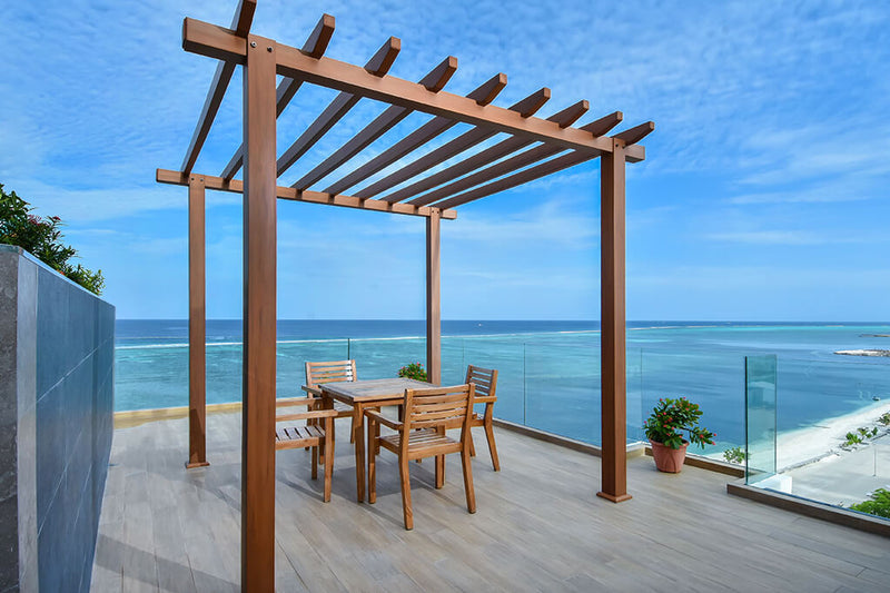 Rooftop terrace with a pergola and dining table overlooking the sea at Triton Prestige