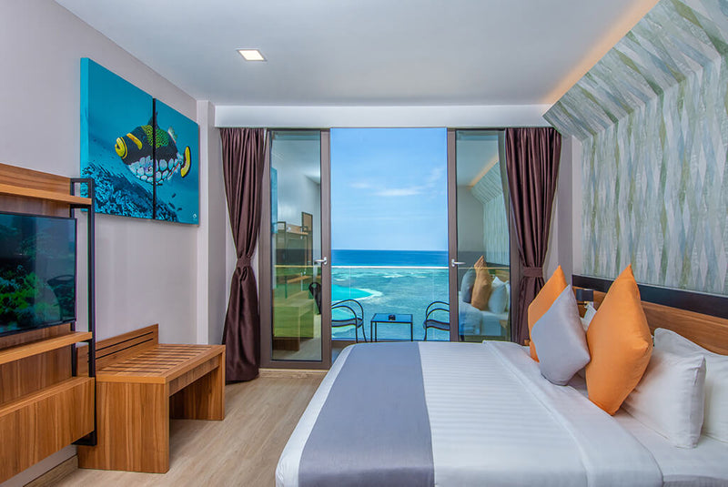 Sea-view room at Triton Prestige with a double bed and balcony doors onto the water