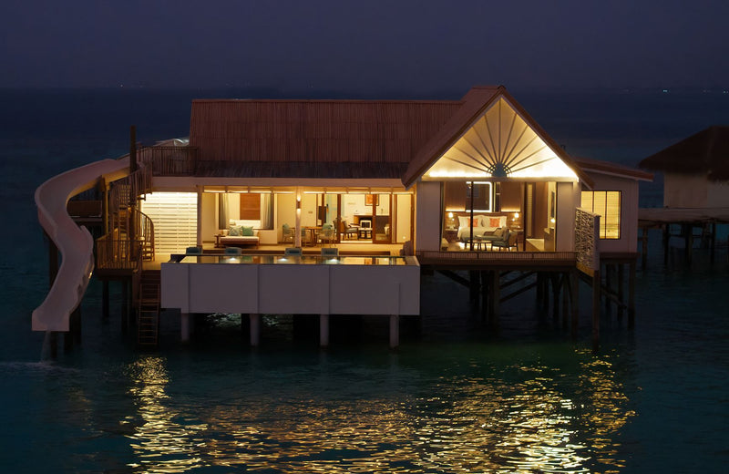 An overwater villa lit at dusk at RAH GILI Maldives.