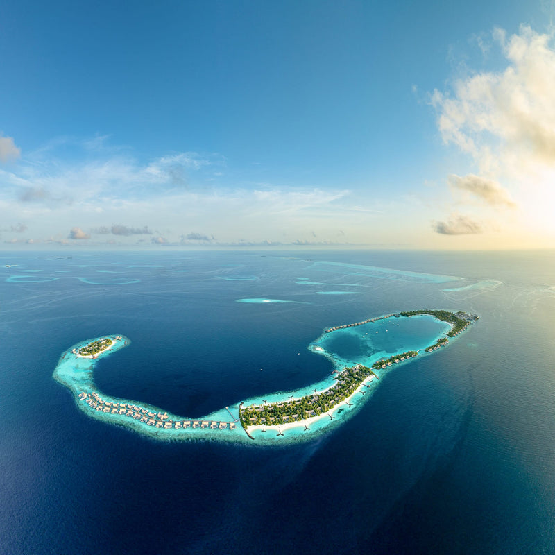 Waldorf Astoria Maldives Ithaafushi, South Malé Atoll: aerial view of the curving islands and the arc of overwater villas in open sea