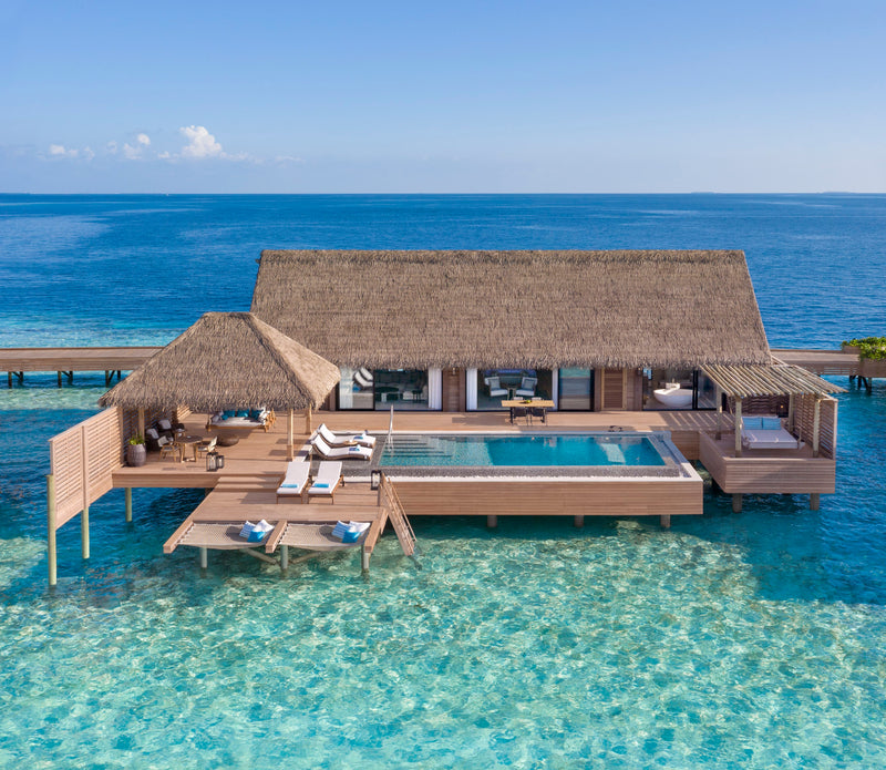 Waldorf Astoria Maldives Ithaafushi, South Malé Atoll: a Grand Overwater Villa and its pool deck seen from the lagoon