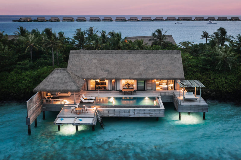 Waldorf Astoria Maldives Ithaafushi, South Malé Atoll: a Grand Reef Villa at dusk, its lit pool deck over the lagoon