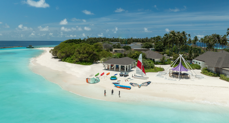 The beach water sports centre at Avani+ Fares Maldives, with sailing boats and kayaks, from the air.