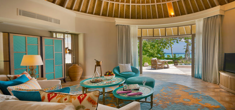 The living room of a Beach House with Private Pool at The Nautilus Maldives, doors open to the garden.