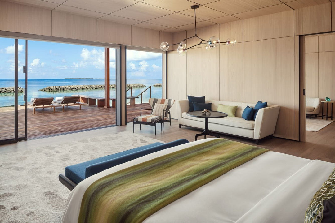 The St. Regis Maldives Vommuli, Dhaalu Atoll — Bedroom with glass onto a deck and seating, the lagoon beyond