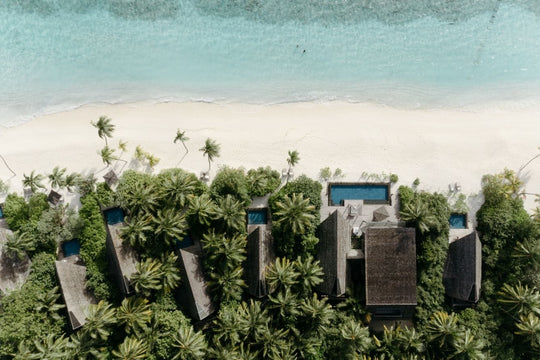 The St. Regis Maldives Vommuli, Dhaalu Atoll — Overhead aerial of beach villas and their pools set among palms behind a white beach