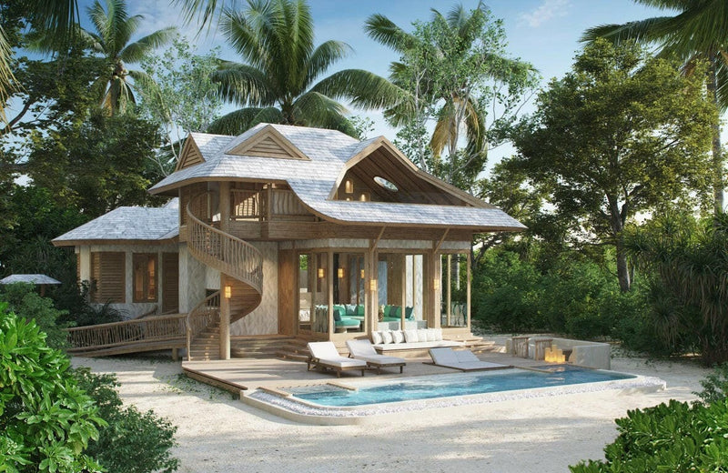 An island villa at Soneva Jani, a spiral timber staircase above a pool set among tall palms.