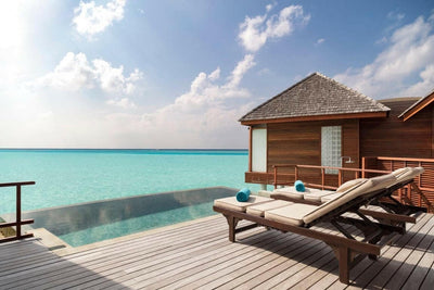 The infinity pool and loungers on the deck of an Over Water Pool Suite at Anantara Dhigu
