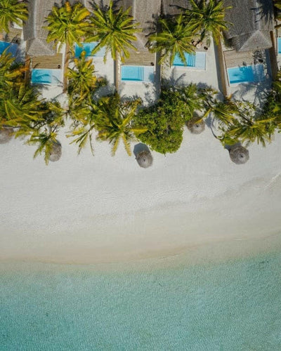 Beach pool villas at Anantara Dhigu from the air, turquoise pools among the palms above the sand