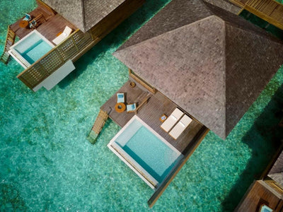 An Over Water Pool Villa at Anantara Veli seen from above, its deck and plunge pool over the lagoon