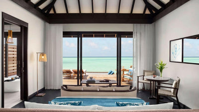 A Deluxe Over Water Pool Villa at Anantara Veli, the bath set in front of wide doors to the lagoon