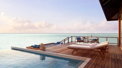 The deck of a Deluxe Over Water Pool Villa at Anantara Veli, daybed and pool looking out to open water