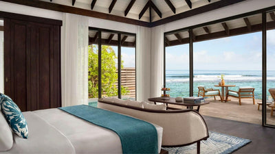 An Ocean Pool Villa bedroom at Anantara Veli, wide doors opening onto the deck and the ocean