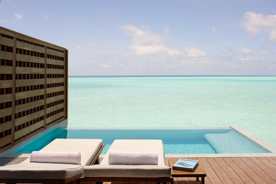 Two loungers beside the plunge pool of an Over Water Pool Villa at Anantara Veli, the lagoon beyond