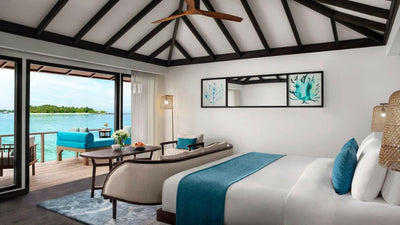 A Superior Over Water Villa at Anantara Veli, the bed facing the deck and its loungers above the water