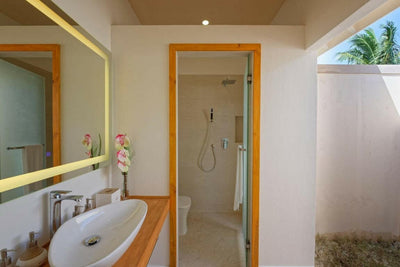 A Bougain Villa bathroom at Brennia Kottefaru, freestanding tub beside a walk-in shower