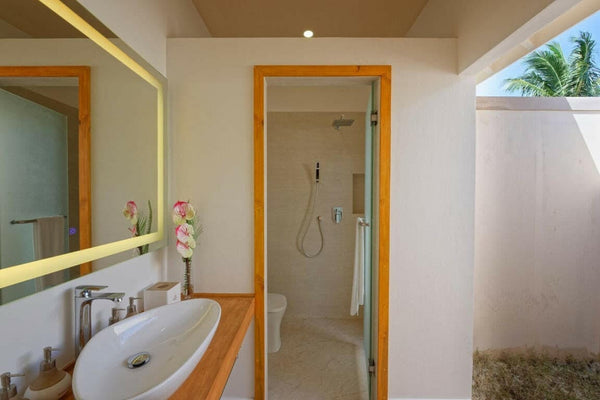 A Bougain Villa bathroom at Brennia Kottefaru, freestanding tub beside a walk-in shower