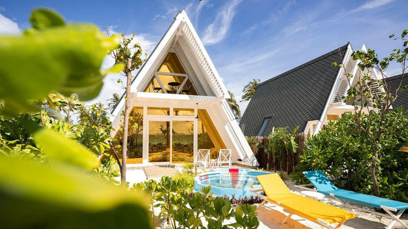Haruge Beach Villas at Oaga Art Resort, steep A-frame roofs and a pool seen through the foliage