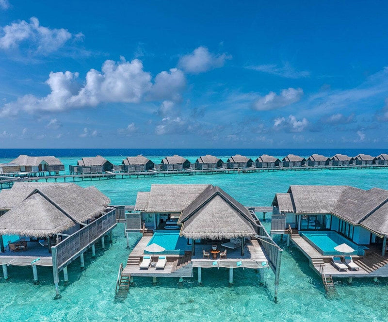 The Overwater Pool Villas at Anantara Kihavah Maldives Villas, thatched roofs and private pools along the lagoon