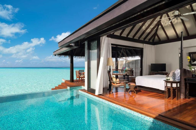 A Sunset Overwater Pool Villa at Anantara Kihavah Maldives Villas, the bedroom opening on to the pool and the lagoon