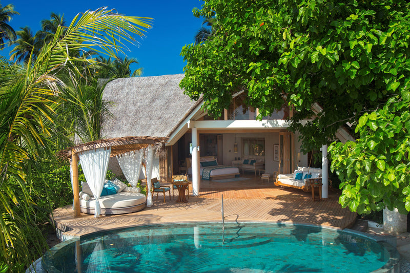 A Beach Pool Villa at Milaidhoo Maldives, curtained daybed on the deck beside a round pool.