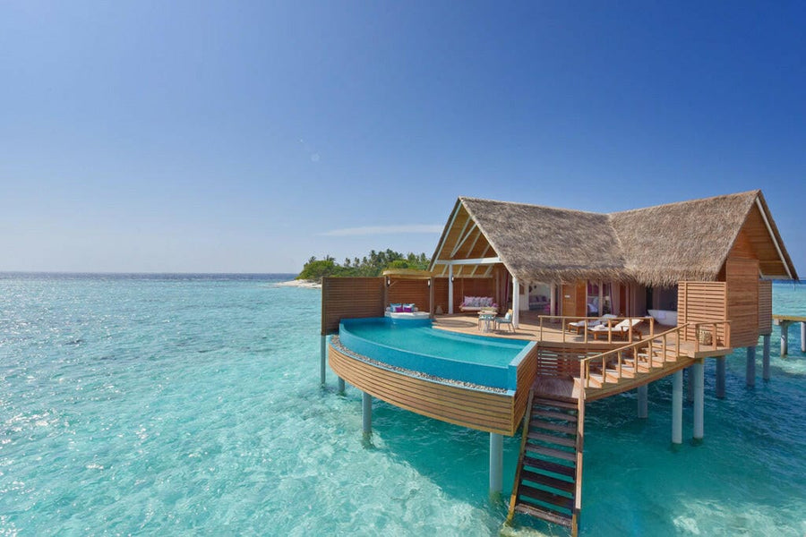 A Water Pool Villa at Milaidhoo Maldives, curved blue pool on the deck above turquoise shallows.