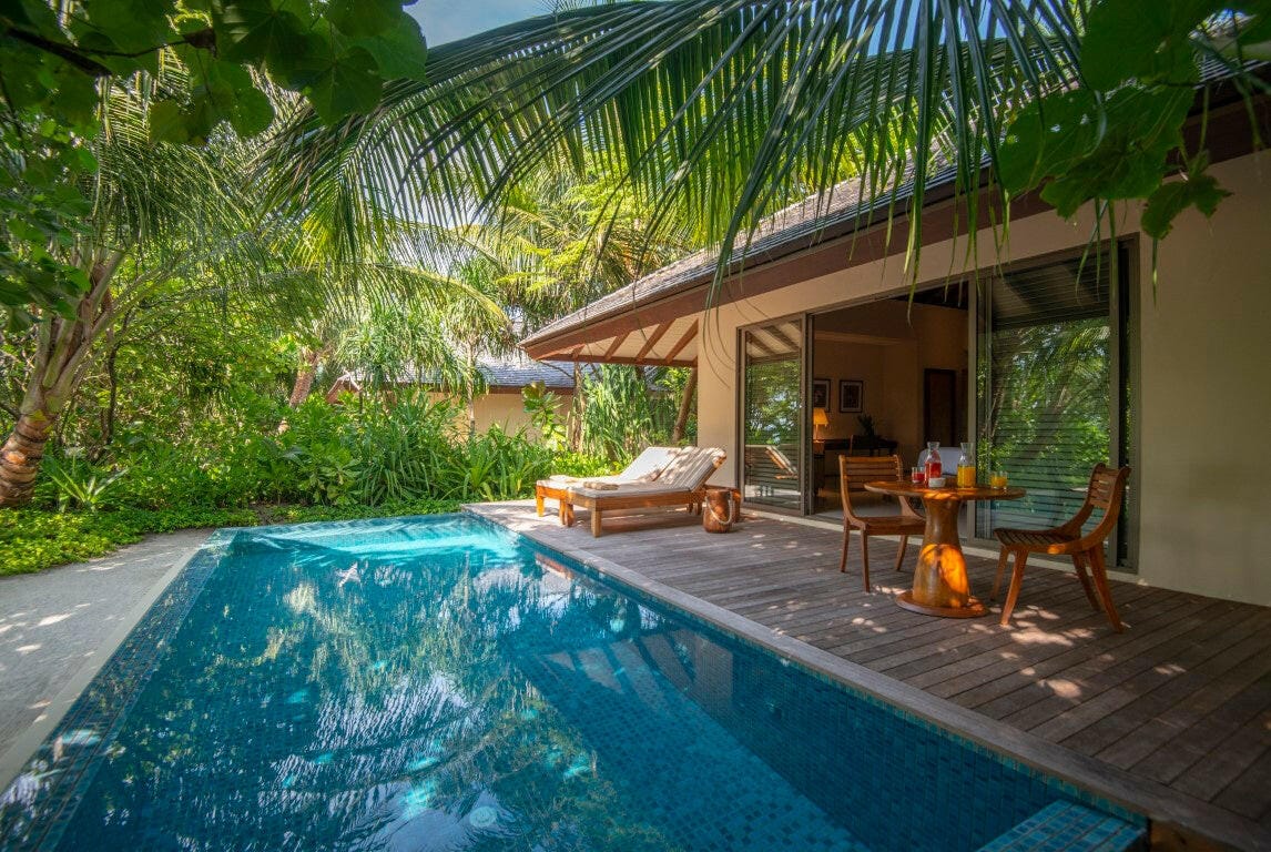 A beach pool villa at The Residence Maldives at Dhigurah, its private pool and loungers in a planted garden