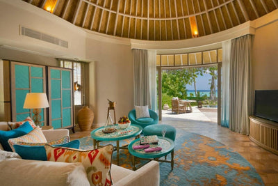 A Beach House sitting room at The Nautilus Maldives, teal shutters and doors onto the garden